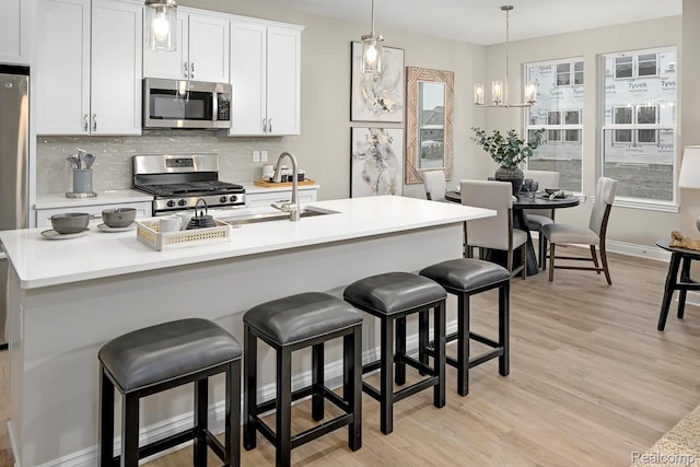 809 Cortland Ln, Troy, MI 48085 - kitchen featuring stainless steel appliances, decorative backsplash, light wood-type flooring, light countertops, and white cabinets