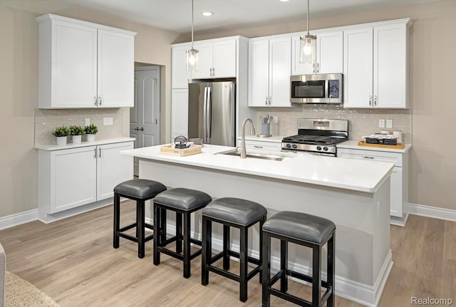 809 Cortland Ln, Troy, MI 48085 - kitchen featuring stainless steel appliances, decorative backsplash, light wood finished floors, a kitchen breakfast bar, and recessed lighting