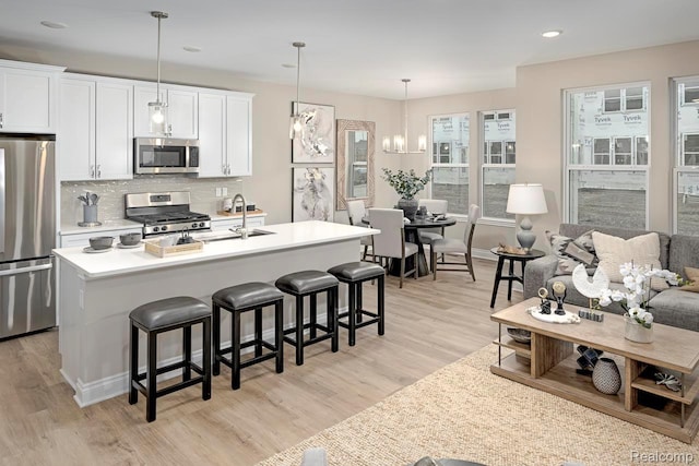 809 Cortland Ln, Troy, MI 48085 - kitchen featuring appliances with stainless steel finishes, light wood-type flooring, a kitchen bar, tasteful backsplash, and recessed lighting