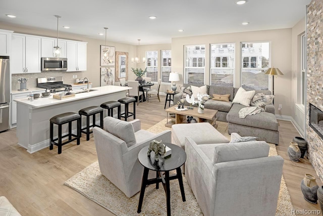 809 Cortland Ln, Troy, MI 48085 - living room with light wood-style floors, recessed lighting, healthy amount of natural light, and a stone fireplace