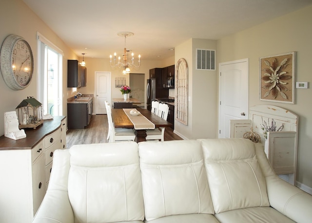 8440 Irish Mist, Onsted, MI 49265 - living room featuring a chandelier and light wood finished floors