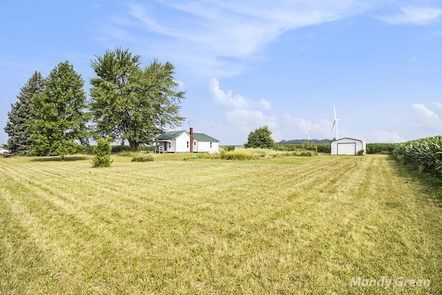 4651 E Pierce Rd, Ithaca, MI 48847 - view of grassy yard with an outdoor structure, a view of countryside, and a garage