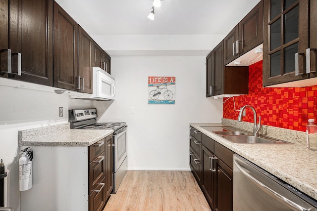 2150 Pauline Blvd Unit 203, Ann Arbor, MI 48103 - kitchen featuring appliances with stainless steel finishes, light countertops, light wood finished floors, dark brown cabinetry, and decorative backsplash
