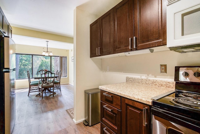 2150 Pauline Blvd Unit 203, Ann Arbor, MI 48103 - kitchen with range with electric cooktop, white microwave, freestanding refrigerator, light wood finished floors, and light countertops
