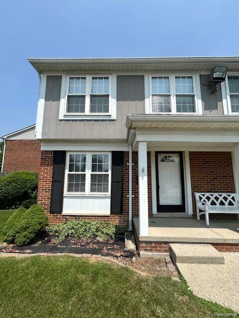 36640 Park Place Dr Unit 56, Sterling Heights, MI 48310 - view of front facade with brick siding and a porch