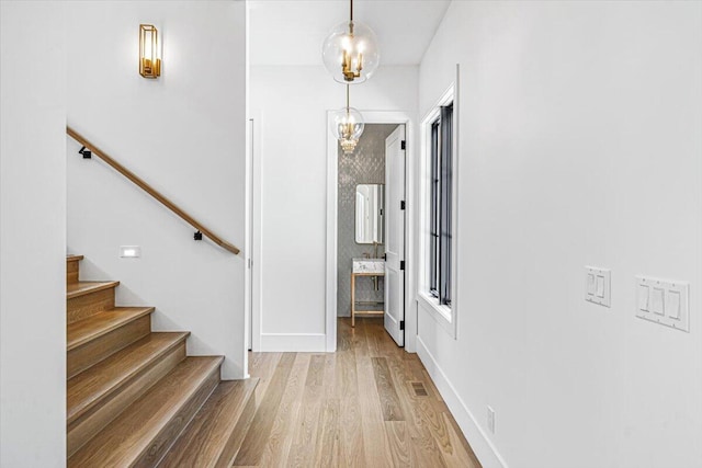 7462 Youngren Rd, Three Oaks, MI 49128 - foyer entrance with a chandelier, stairs, and light wood-style flooring