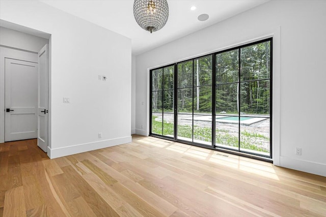 7462 Youngren Rd, Three Oaks, MI 49128 - empty room featuring light wood-type flooring and a chandelier