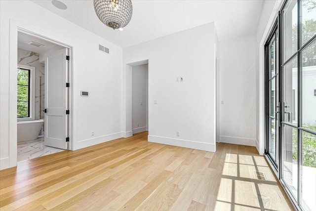 7462 Youngren Rd, Three Oaks, MI 49128 - unfurnished room featuring light wood-style floors and a chandelier