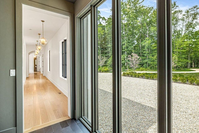 7462 Youngren Rd, Three Oaks, MI 49128 - doorway to outside featuring arched walkways, dark wood-style floors, and a chandelier