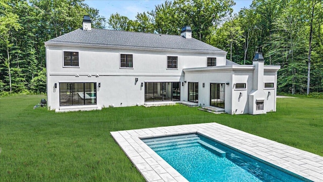 7462 Youngren Rd, Three Oaks, MI 49128 - back of property featuring a chimney, stucco siding, a lawn, and an outdoor pool