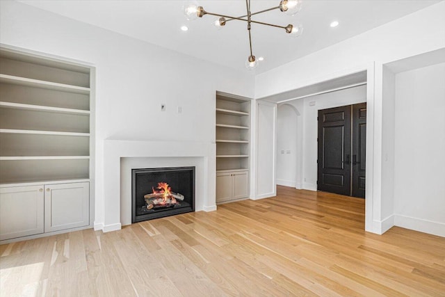 7462 Youngren Rd, Three Oaks, MI 49128 - unfurnished living room with a chandelier, light wood-style flooring, built in shelves, and recessed lighting