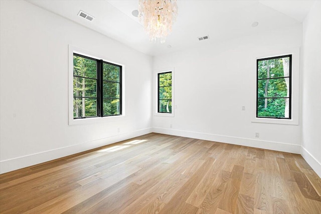 7462 Youngren Rd, Three Oaks, MI 49128 - spare room featuring light wood-type flooring and a chandelier