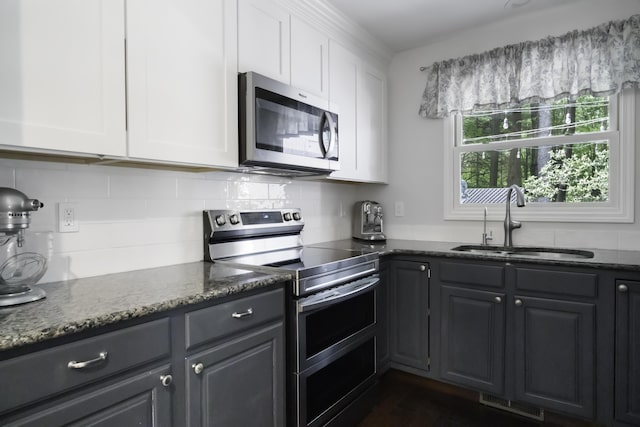 1227 Beech Dr, South Haven, MI 49090 - kitchen featuring appliances with stainless steel finishes, white cabinetry, and backsplash