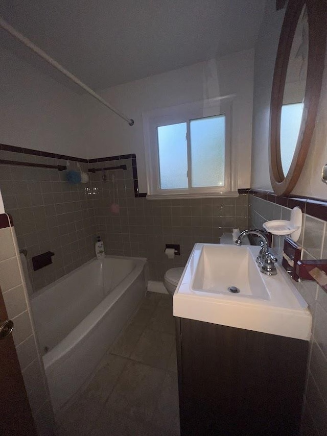 4518 Huckleberry Ln, Flint, MI 48507 - full bathroom featuring  shower combination, vanity, tile walls, tile patterned floors, and a wainscoted wall