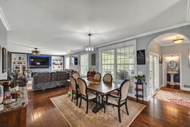 3725 S Creek Ln, Dryden, MI 48428 - dining area featuring dark wood-type flooring, arched walkways, crown molding, and built in shelves