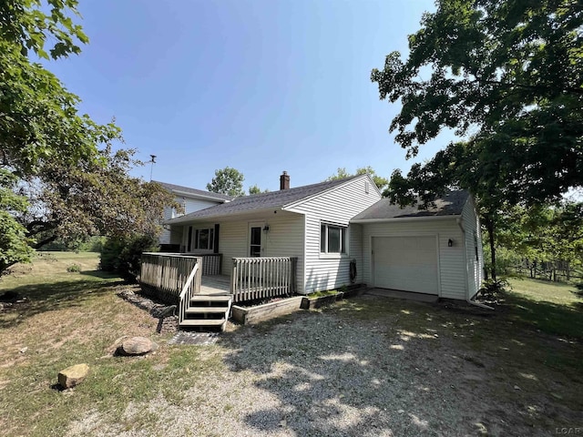 1569 N Rollin Hwy, Hudson, MI 49247 - view of front of house with an attached garage, driveway, a chimney, a wooden deck, and a front lawn