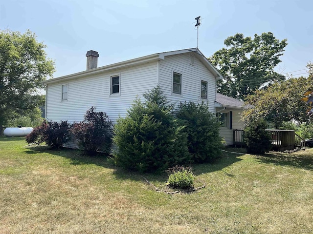 1569 N Rollin Hwy, Hudson, MI 49247 - view of side of home featuring a lawn, a chimney, and a wooden deck