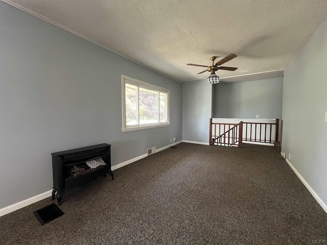 1569 N Rollin Hwy, Hudson, MI 49247 - unfurnished room with a textured ceiling, a ceiling fan, dark carpet, and a wood stove