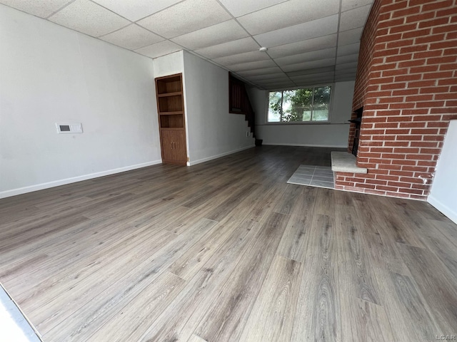 1569 N Rollin Hwy, Hudson, MI 49247 - unfurnished living room featuring a paneled ceiling, wood finished floors, and stairway