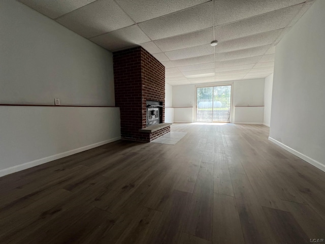 1569 N Rollin Hwy, Hudson, MI 49247 - unfurnished living room featuring a drop ceiling, wood finished floors, and a fireplace