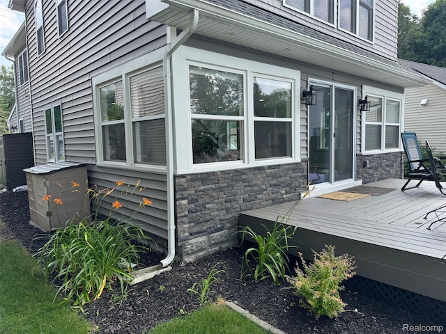 677 King Cir, Lake Orion, MI 48362 - view of side of property with a deck, stone siding, and a shingled roof