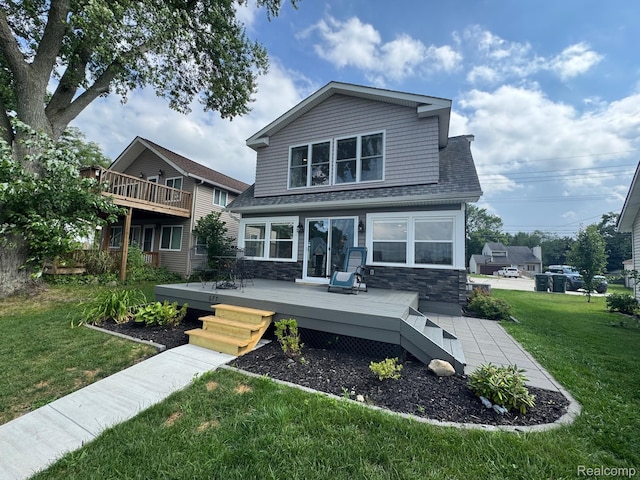 677 King Cir, Lake Orion, MI 48362 - rear view of property featuring a lawn, stone siding, a wooden deck, and roof with shingles