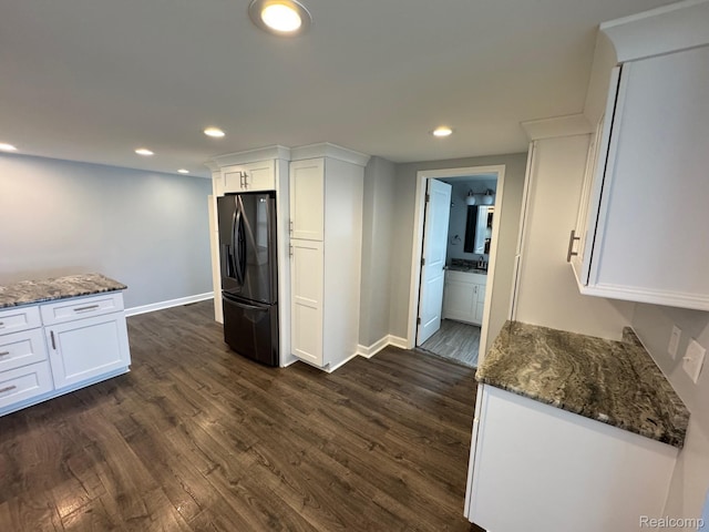677 King Cir, Lake Orion, MI 48362 - kitchen featuring black fridge, white cabinetry, dark wood-style flooring, dark stone countertops, and recessed lighting