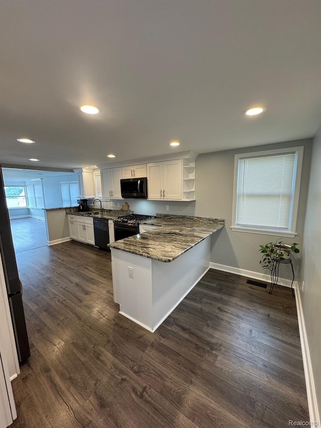 677 King Cir, Lake Orion, MI 48362 - kitchen featuring a peninsula, dark wood-type flooring, open shelves, dark stone counters, and recessed lighting