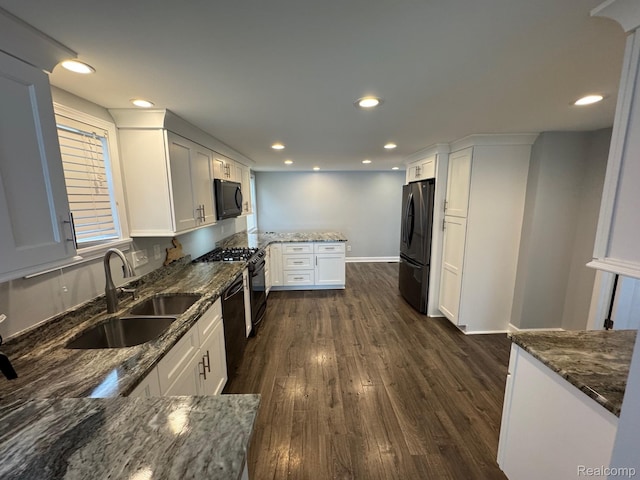 677 King Cir, Lake Orion, MI 48362 - kitchen with a peninsula, dark stone countertops, dark wood-type flooring, and recessed lighting