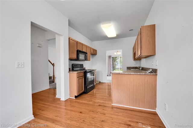1236 University Dr, Pontiac, MI 48342 - kitchen with black appliances, light wood-style floors, and brown cabinetry