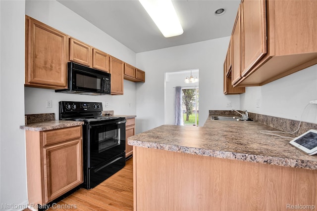 1236 University Dr, Pontiac, MI 48342 - kitchen featuring black appliances, light wood-style flooring, and a peninsula
