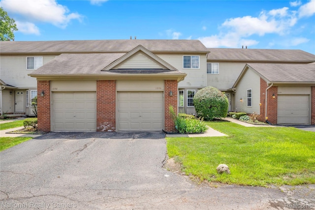 1236 University Dr, Pontiac, MI 48342 - traditional home with brick siding, a front yard, asphalt driveway, and an attached garage