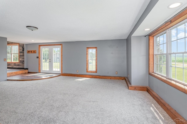 5010 N Pendell Rd, Alma, MI 48801 - unfurnished living room featuring plenty of natural light, carpet flooring, and a textured ceiling