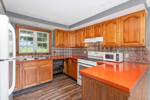 5010 N Pendell Rd, Alma, MI 48801 - kitchen with white appliances, a textured ceiling, brown cabinets, under cabinet range hood, and tasteful backsplash