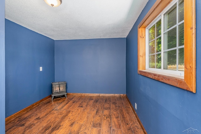 5010 N Pendell Rd, Alma, MI 48801 - bonus room with a wood stove, a textured ceiling, and wood finished floors