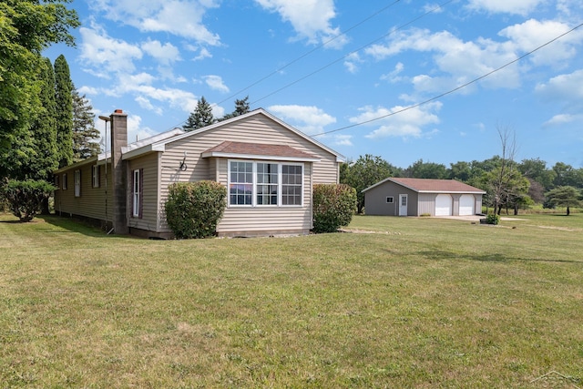 5010 N Pendell Rd, Alma, MI 48801 - view of home's exterior with a chimney, a yard, and a detached garage