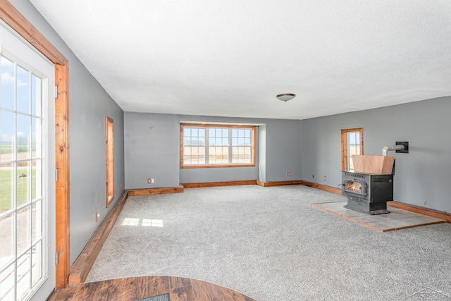 5010 N Pendell Rd, Alma, MI 48801 - unfurnished living room featuring a wood stove and carpet