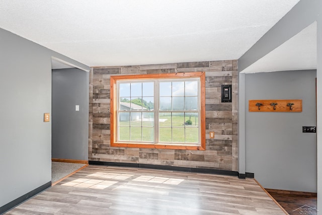 5010 N Pendell Rd, Alma, MI 48801 - empty room with wood finished floors, wooden walls, and an accent wall