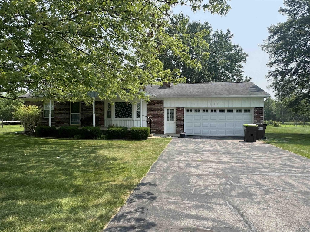 6967 Green Hwy, Tecumseh, MI 49286 - view of front of home featuring driveway, a front lawn, brick siding, and an attached garage