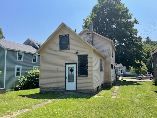 262 5th St, Manistee, MI 49660 - rear view of property with a yard and a chimney