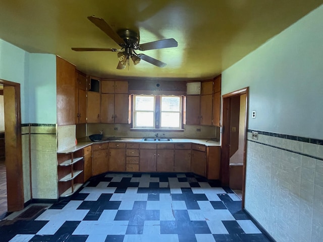 262 5th St, Manistee, MI 49660 - kitchen with dark floors, wainscoting, ceiling fan, light countertops, and tile walls