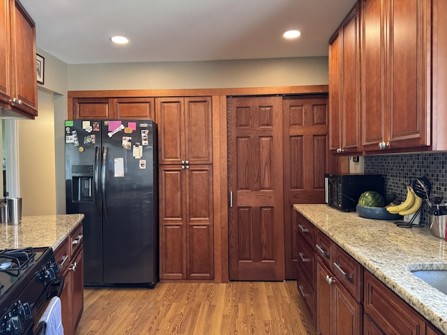 39909 Bridgeview St, Harrison Township, MI 48045 - kitchen featuring black appliances, light wood-style floors, light stone countertops, tasteful backsplash, and recessed lighting