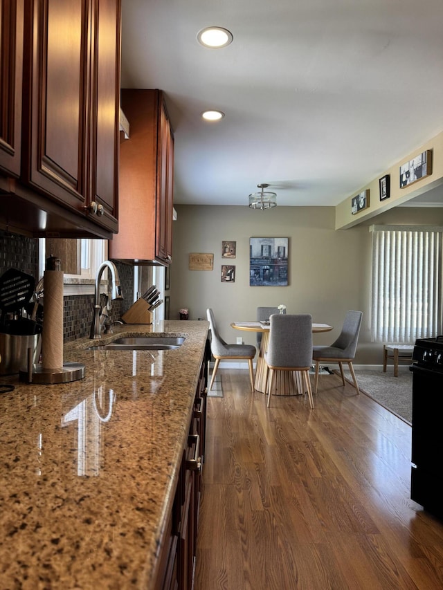 39909 Bridgeview St, Harrison Township, MI 48045 - kitchen with light stone countertops, dark wood finished floors, backsplash, recessed lighting, and stove