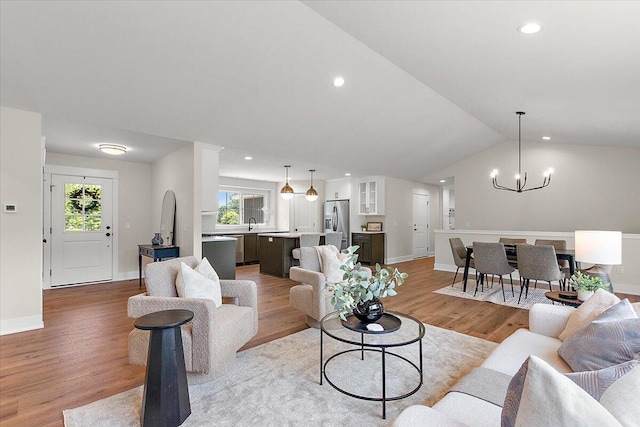 6766 Baldwin St, Hudsonville, MI 49426 - living room featuring a chandelier, light wood-type flooring, recessed lighting, and vaulted ceiling