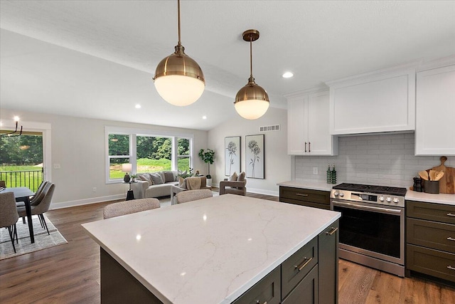 6766 Baldwin St, Hudsonville, MI 49426 - kitchen with stainless steel range oven, white cabinetry, backsplash, open floor plan, and recessed lighting