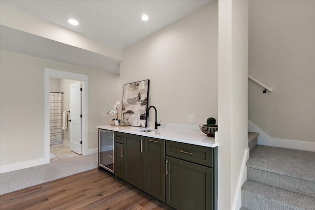 6766 Baldwin St, Hudsonville, MI 49426 - bar area featuring beverage cooler, stairs, light carpet, recessed lighting, and light wood-style flooring