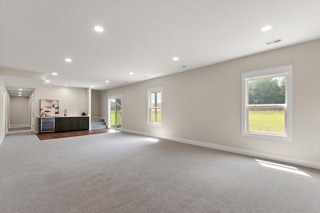 6766 Baldwin St, Hudsonville, MI 49426 - unfurnished living room featuring carpet flooring, healthy amount of natural light, recessed lighting, and beverage cooler