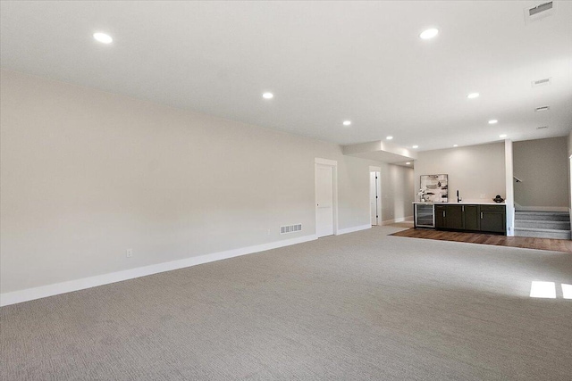 6766 Baldwin St, Hudsonville, MI 49426 - unfurnished living room with carpet floors, recessed lighting, wine cooler, and bar area