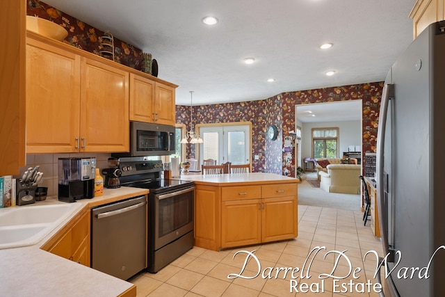 2711 Byron Station Dr SW, Byron Center, MI 49315 - kitchen with wallpapered walls, a peninsula, stainless steel appliances, recessed lighting, and light countertops