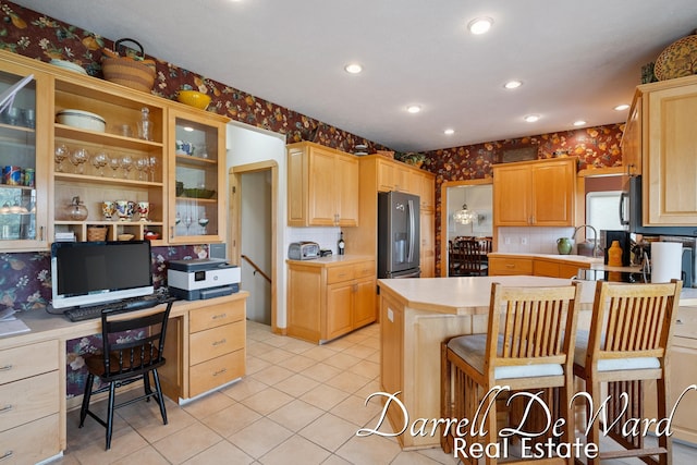 2711 Byron Station Dr SW, Byron Center, MI 49315 - kitchen featuring wallpapered walls, built in desk, light countertops, light tile patterned floors, and stainless steel fridge with ice dispenser